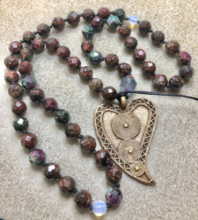 Faceted stone bead necklace with a metallic heart pendant